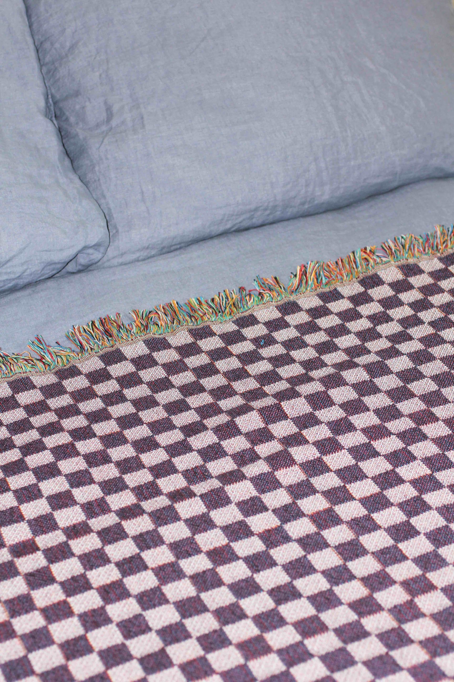Back of 'Eat your Greens' micro check blanket on bed
