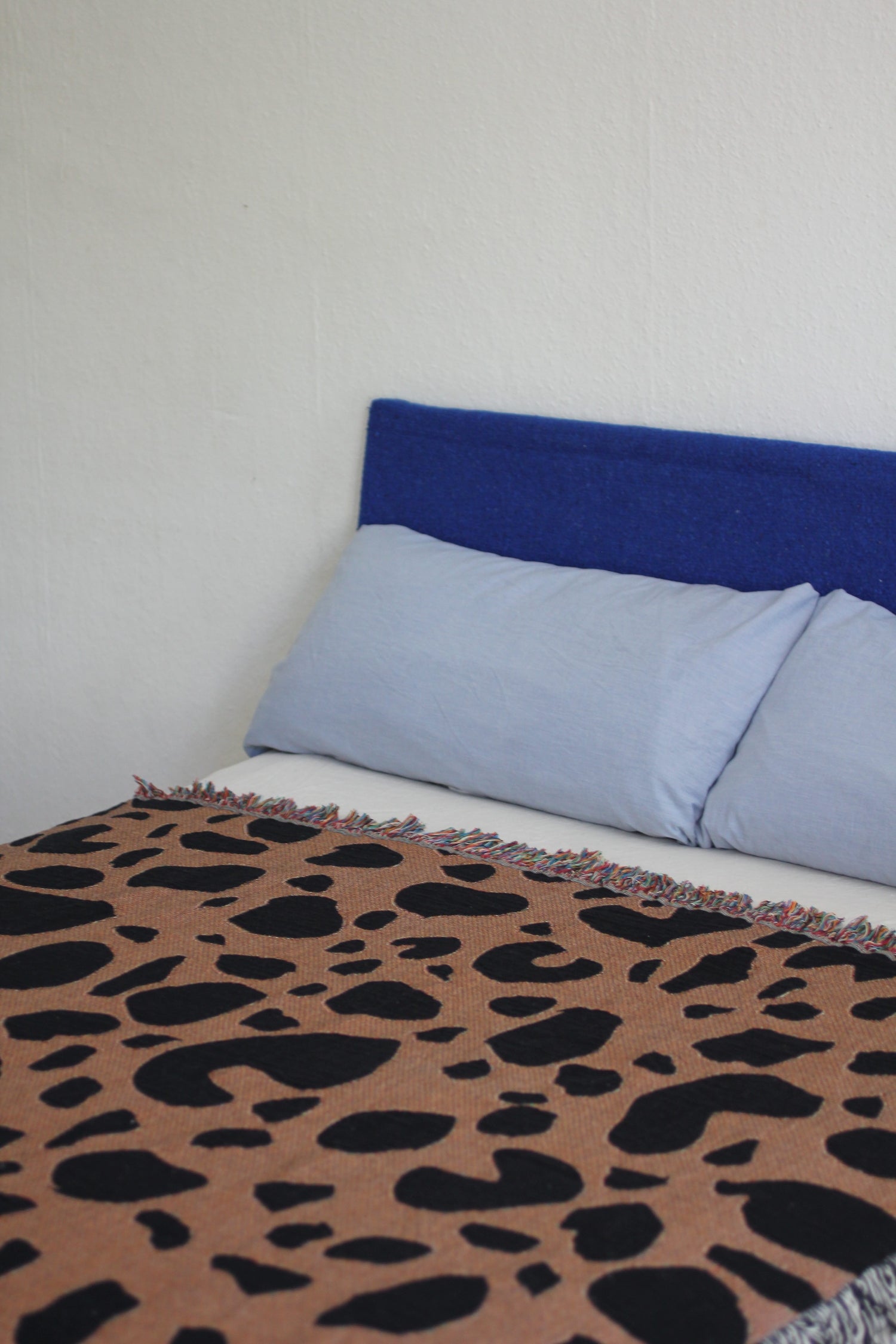 Wild Thing woven throw blanket on a bed.